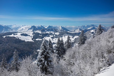 Winter landscape covered in deep snow at the summit of the Zwoelferhorn with a view of the Osterhorn group