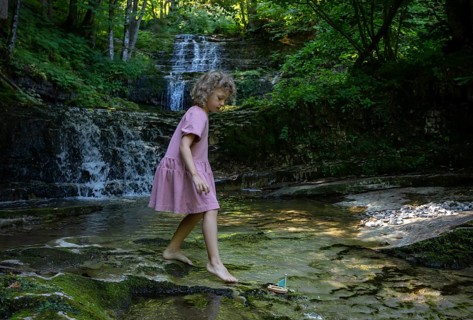 Girl playing on the bank of the Taugl at the Wald Wasser Zauber Weg near Hintersee