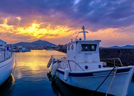 Colorful sunset over quiet Greek fishing village and its harbour