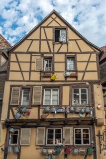 Facade of a traditional Alsatian house decorated with old water jugs