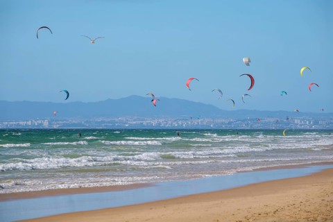 Kiteboarding kitesurfing kiteboarder kitesurfer kites on the Atlantic ocean beach at Fonte da Telha beach