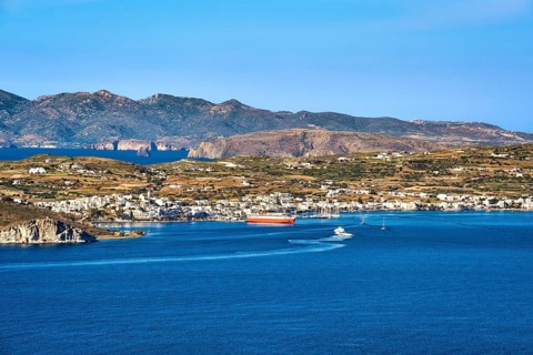 Beautiful summer day and sunshine in typical port town of Greek island. Whitewashed houses by waterfront