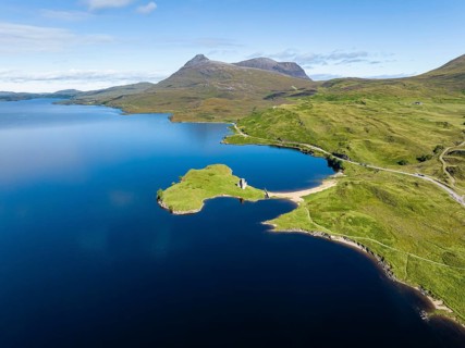 Aerial view of the freshwater loch Loch Assynt with the ruins of Ardvreck Castle on a peninsula