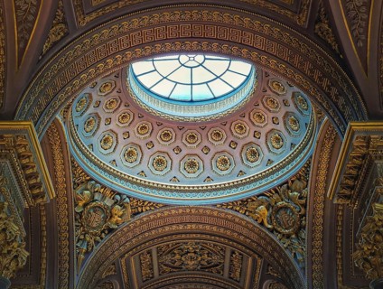 Closeup architectural details of the dome and golden ornate ceiling inside the Versailles palace hall