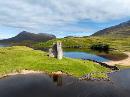 Aerial view of the freshwater loch Loch Assynt with the ruins of Ardvreck Castle on a peninsula