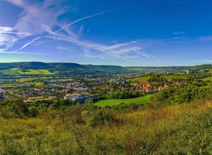 View over the city of Jena from the Galgenberg with the Kernberge in the background under blue sky and veil clouds