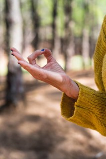 Chin mudra close up over nature background. Vertical shot