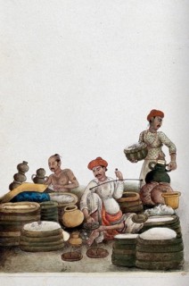Selling rice at a bazaar. A trader weighs rice at an outdoor market. Rice is the staple food in India and symbolises prosperity