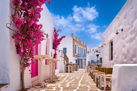 Beautiful street of Greek island town on sunny summer day. Whitewashed houses