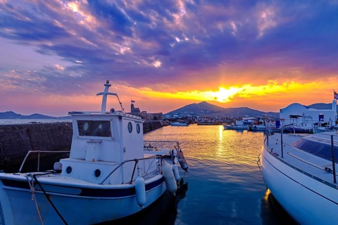 Colorful sunset over quiet Greek fishing village and its harbour