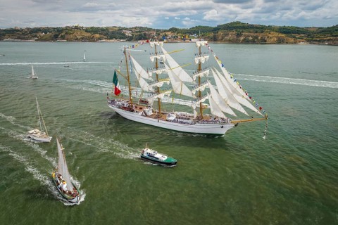 Aerial drone view of tall ships with sails sailing in Tagus river towards the Atlantic ocean in Lisbon