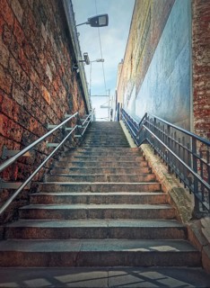 Narrow outside stairway between the walls. Abstract view upstairs
