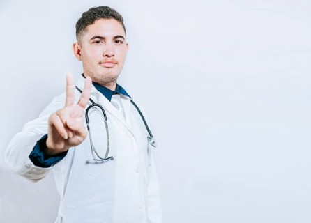 Latin doctor counting number two isolated. Smiling young doctor counting number 2 on isolated background