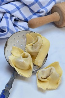Freshly prepared tortelloni in a sieve ladle