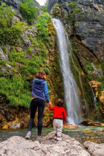Mother with her son Grunas waterfall of Theth national park in summer