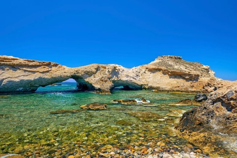 Sunny landscape of rocky small bay with azure clear sea waters