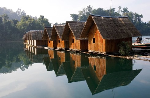 Bamboo raft huts with mirror image at Lake Ratchaprabha