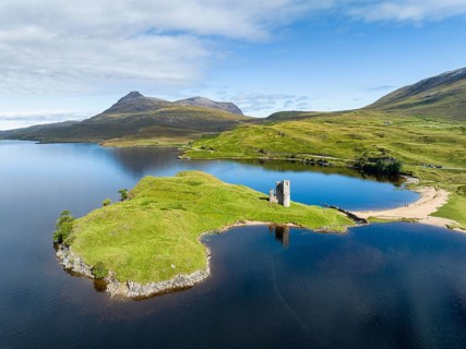 Aerial view of the freshwater loch Loch Assynt with the ruins of Ardvreck Castle on a peninsula