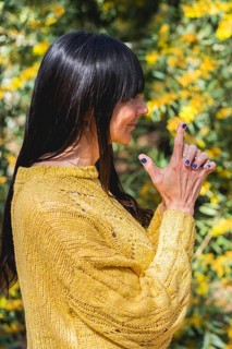 Side view of Kali mudra executed by a woman over nature background