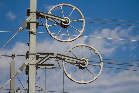 Railway line mast with wheel tensioning station