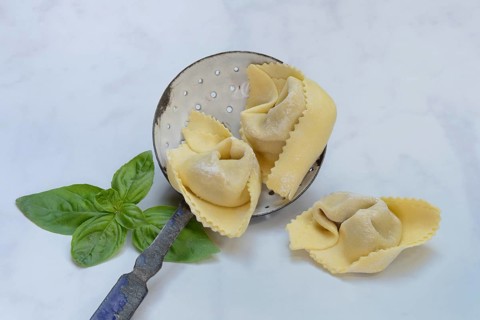 Freshly prepared tortelloni in a sieve ladle