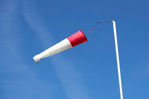 White-red windsock against blue sky