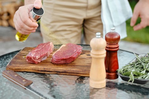 Sprinkling club beef steak with olive oil