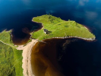 Aerial view of the freshwater loch Loch Assynt with the ruins of Ardvreck Castle on a peninsula
