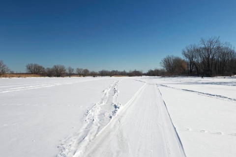 Vehicle tracks on snow covered frozen river