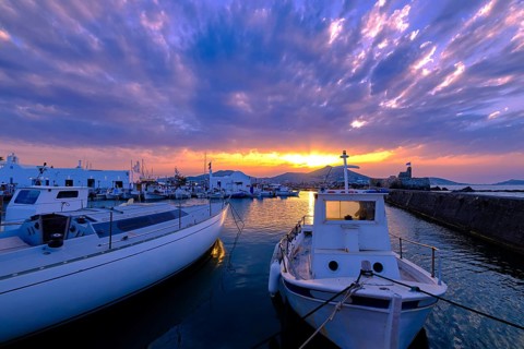 Colorful sunset over quiet Greek fishing village and its harbour
