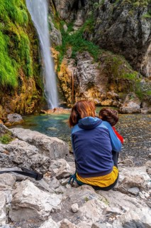 Woman with her child at Grunas waterfall in Theth national park