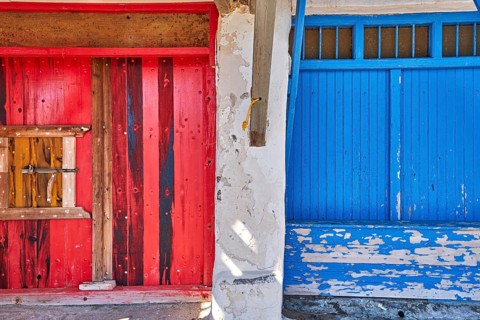 Colorful blue and red boat garage doors in Klima fishermen village