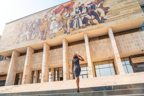 A female tourist walking up the stairs to the National Historical Museum in Skanderbeg Square in Tirana. Albania