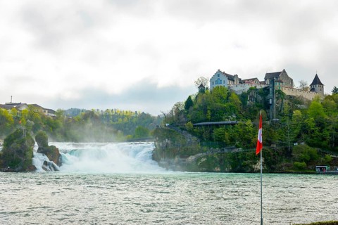 Rhine Falls and Swiss Flag with the Castle Laufen at Neuhausen in Schaffhausen