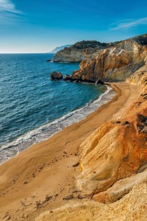 Beautiful sunset view of secluded and remote beach on sunny evening. High yellow cliffs
