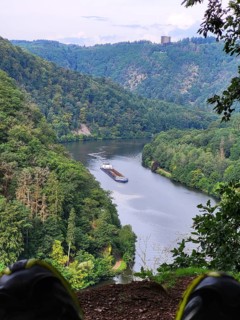 Aerial view of the Saar Loop. The Saar winds through the valley and is surrounded by green forests. Orscholz