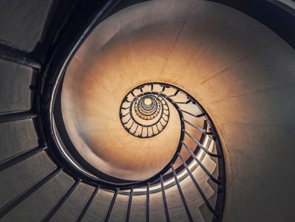 Abstract view of a circular staircase with black metal railing
