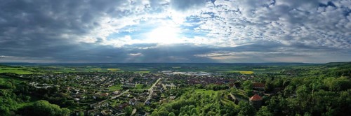 Aerial view of Koenigsberg in Bavaria. The city is surrounded by hills and forests. The sky is cloudy and dark