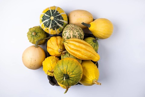 Various ornamental pumpkins in and next to baskets