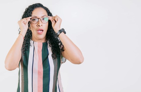 Surprised woman taking off glasses isolated. Amazed afro girl taking off glasses by a promotion