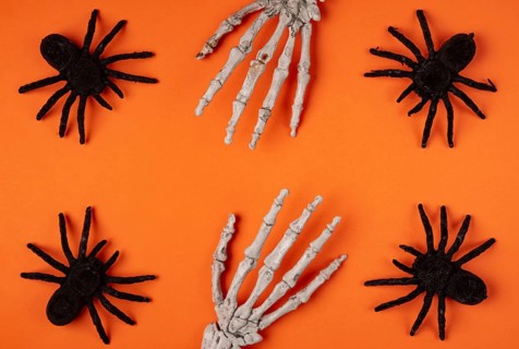Black spiders and skeleton hands on orange