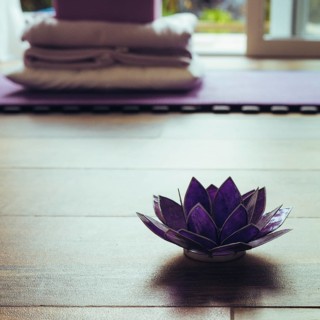 Glass lotus decorative on a woodn floor. Yoga concept