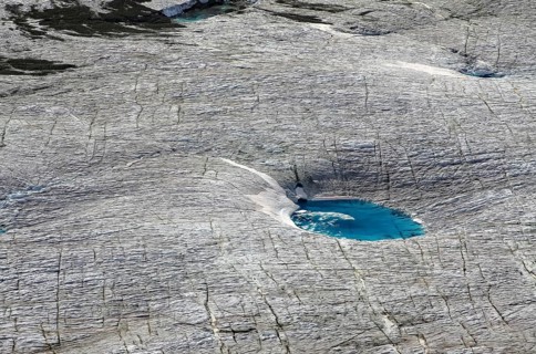 Meltwater lake with blue water on glacier