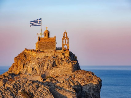 Chapel of St. Paisios perched on rocks at sunrise