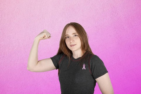 Woman wearing a pink breast cancer awareness ribbon. Concept of struggle with breast cancer