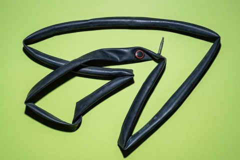 Top view of a flat bicycle tube against a blue background