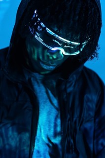 Close-up studio photo with blue neon light of a futuristic man with artificial intelligence headset