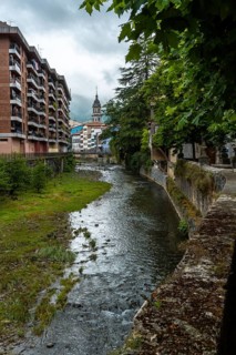 Traditional houses in the town of Azkoitia next to the Urola river and Church of Santa Maria La Real in the background