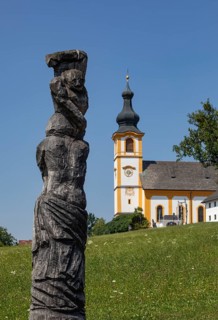 Wooden sculptures at the Stations of the Cross on Kirchberg with parish church