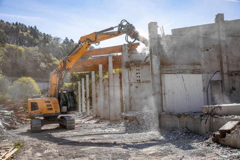 Yellow Liebherr crawler excavator recycling on demolition site